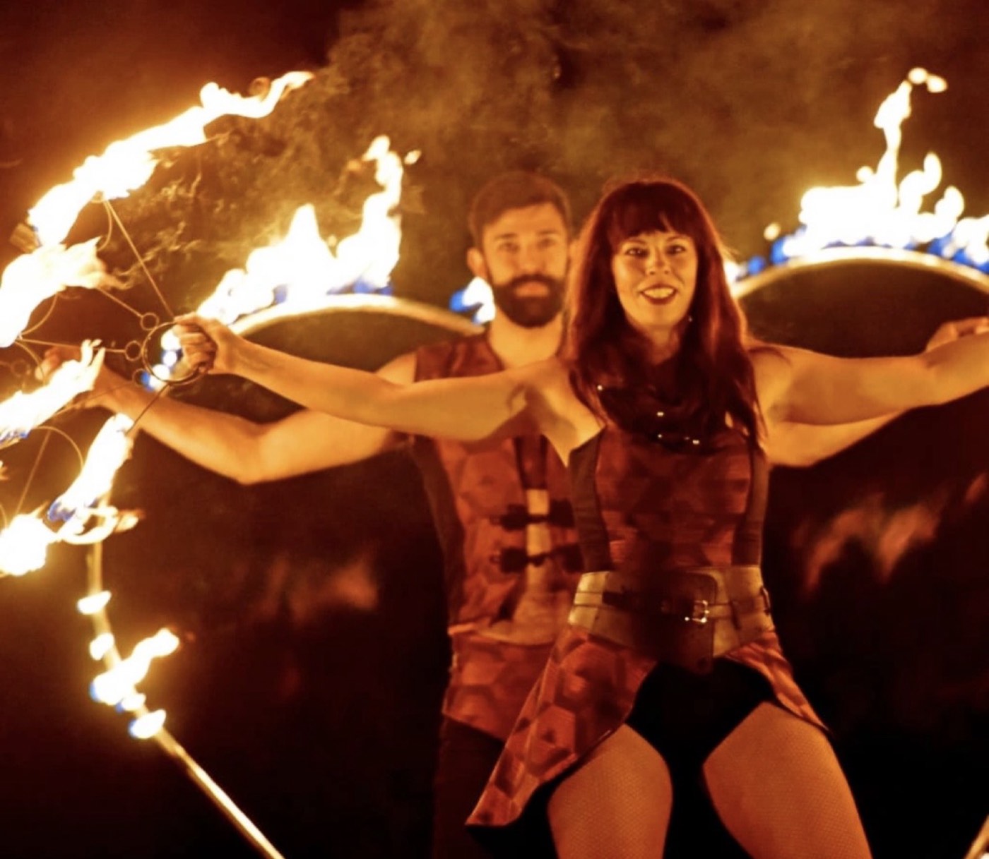 Two fire performers spinning flaming props during the evening entertainment at the Abbey Park Bonfire display.
