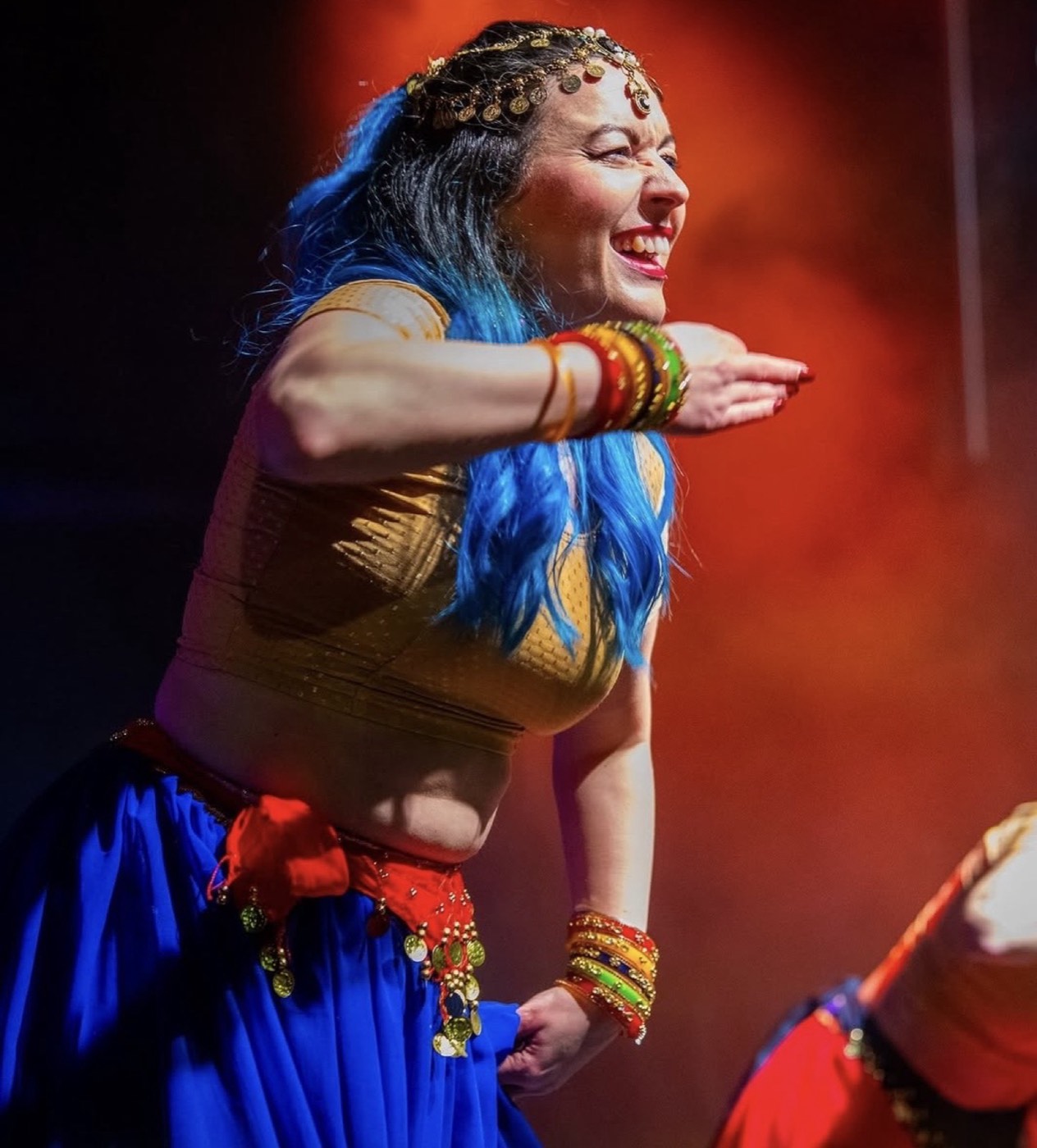 A dancer performing on stage at the Diwali Festival, mid-movement under warm stage lighting.