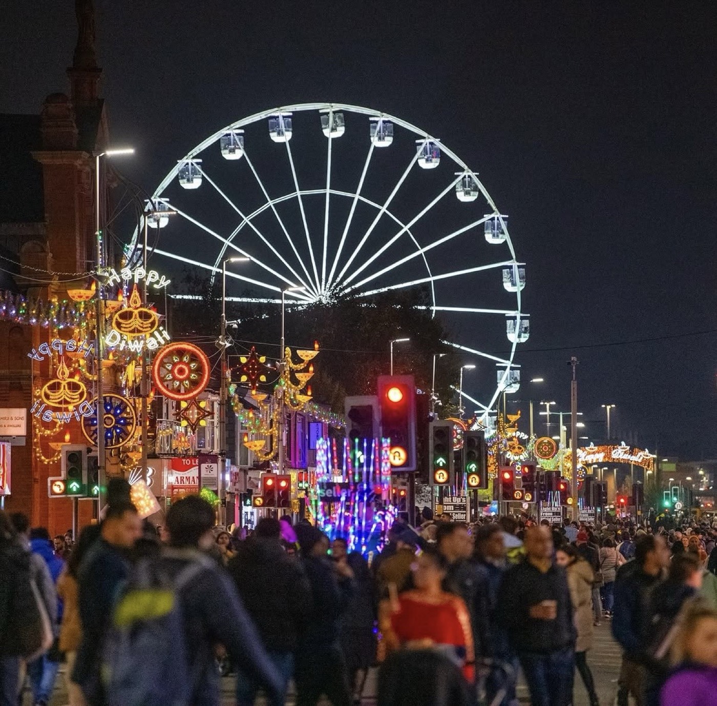 Large public festival in progress, crowd gathered under string lighting.
